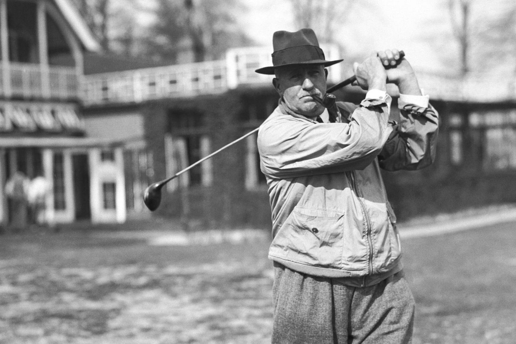 man mid swing with a golf club